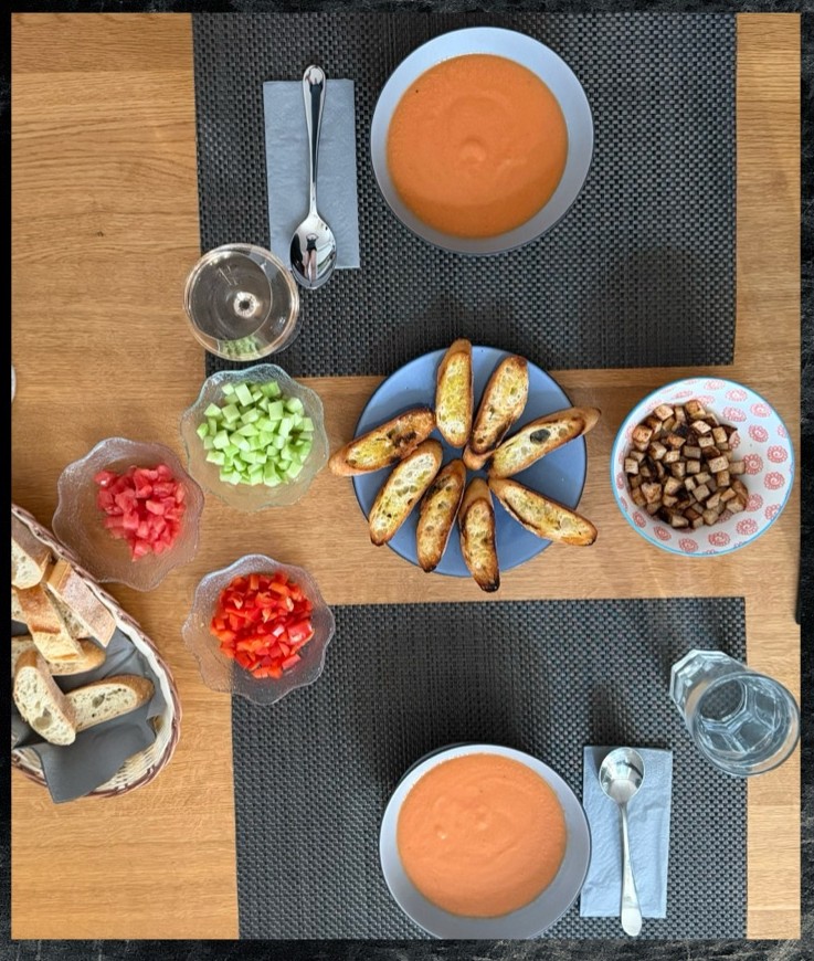 Tisch gedeckt mit Gazpacho, Croutons und Beilagen